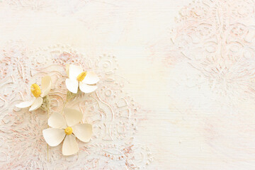 Top view image of white dry flowers over wooden vintage background with ornaments .Flat lay