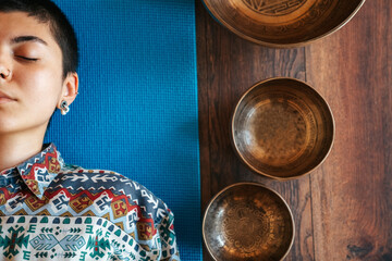 view from above The girl is meditating Tibetan singing bowl in sound therapy
