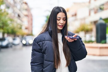 Young beautiful hispanic woman smiling confident talking on smartphone at street