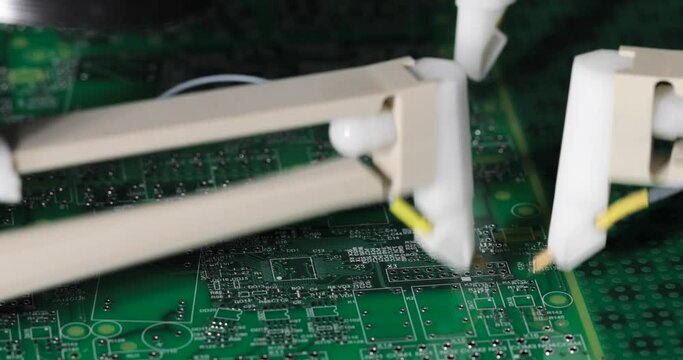 Close-up needles on automatic equipment manufactoring testing circuit boards.