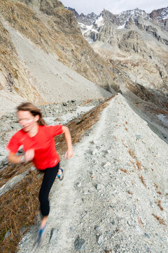 Woman trail running above the Glacier Noir.