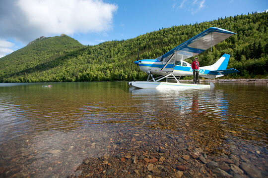 A man stands with a plane in Alaska.