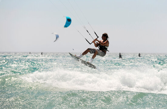 A man catches some air kitesurfing.