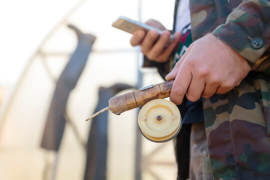 Man holding fishing rod and smartphone