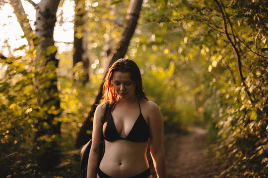 Sensual woman in a bikini walking in forest