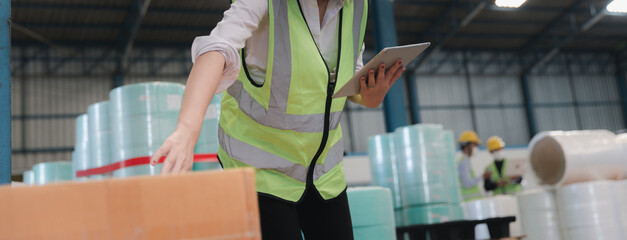 Factory worker using digital tablet checking stock in warehouse or store