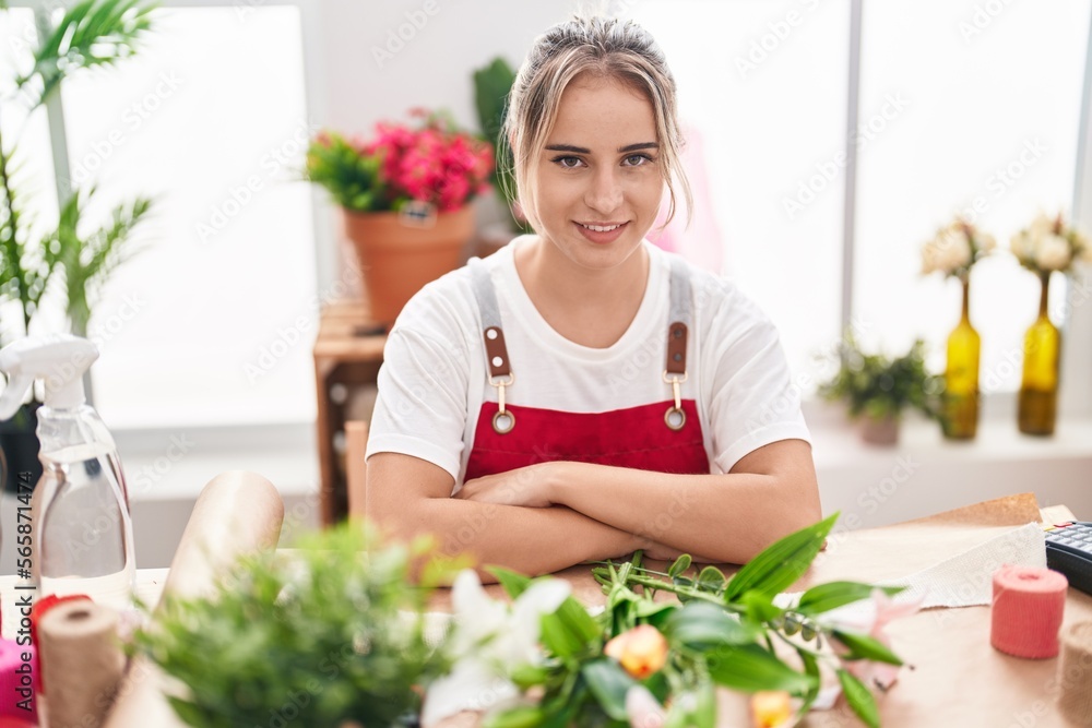 Sticker young blonde woman florist smiling confident sitting with arms crossed gesture at flower shop