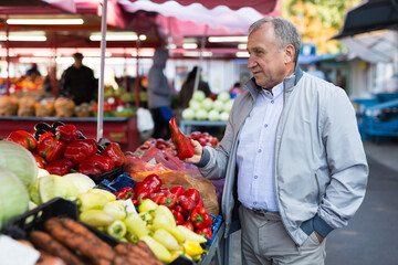 Middle aged man buying peppers