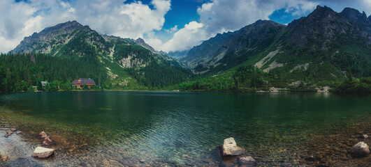 Panoramic view of mountains and Poprad Lake (Popradske pleso) in High Tatras National Park. Slovakia. Europe. Mountain hiking. Concept of travel lifestyle, harmony with nature. Nature background.