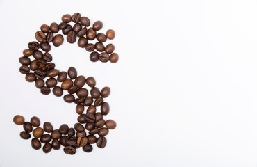 S is a capital letter of the English alphabet made up of natural roasted coffee beans that lie on a white background. Plenty of space to put text or pictures, top view and studio photography.