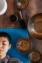 view from above The girl is meditating Tibetan singing bowl in sound therapy