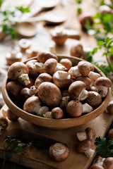Fresh brown mushrooms in a ceramic rustic bowl,  close-up view. Organic brown champignons
