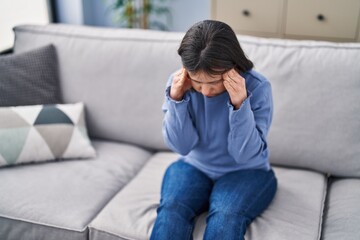 Young woman with down syndrome stressed sitting on sofa at home © Krakenimages.com