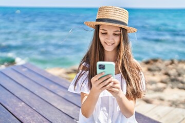 Adorable girl tourist smiling confident using smartphone at seaside