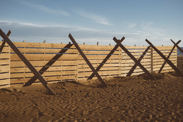 Barricate di legno sulla spiaggia di Lignano Sabbiadoro, durante una giornata invernale al tramonto.