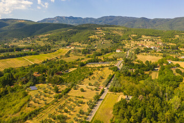 Fototapeta na wymiar Drone photography of small rural town surrounded by agricultural fields, vineyards and olive trees during summer day