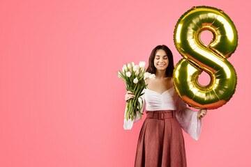 Cheerful young caucasian woman with closed eyes hold bouquet of flowers, inflatable gold balloon...