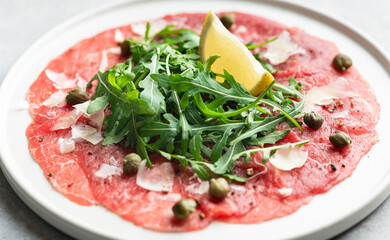 Traditional italian Beef carpaccio with arugula, close-up, selective focus