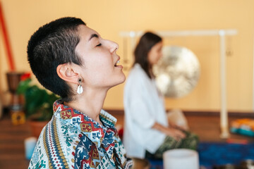 girls on a yoga class. Girls doing yoga and breathing practices Tibetan singing bowl in sound...