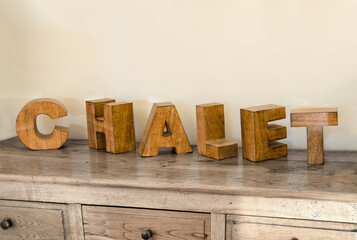 wooden cubes forming the word Chalet, placed on a furniture and used for decoration purposes.