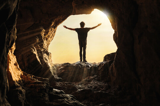 A young man was standing at the mouth of a cave with his arms outstretched, praying for a blessing from God.