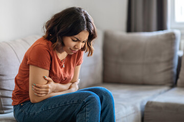 Fototapeta premium Depression Concept. Sad Young Arab Woman Sitting On Couch At Home