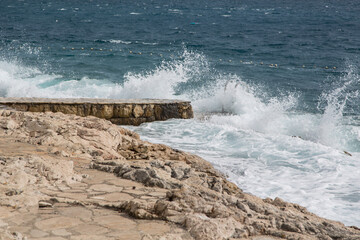 No bathing because of stormy weather and stormy sea with splashing waves along the rocky seafront promenade of Hvar, Croatia