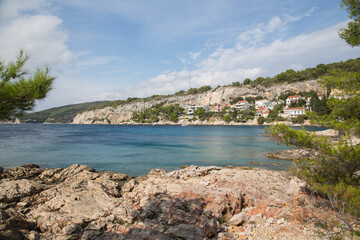 Bay with crystal clear turquoise water surrounded by a rocky coast and pinewood near Podstine beach and the city of Hvar on the island Hvar, Croatia
