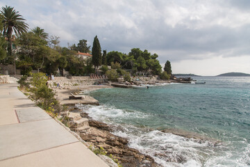 Delightful paved seafront promenade surrounded by pinewood and beautiful nature-with restaurants, bars, cosy sun beds as well as great views to the turquoise water and Pakleni islands-Hvar,Croatia 