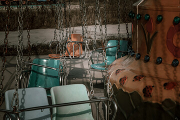 An old amusement ride in an abandoned amusement park. Abandoned carousel and cars. Sunny day. Old...