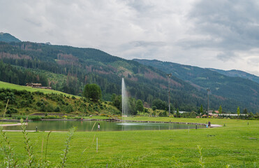 Fototapeta na wymiar Predazzo bio-lake: a green area of the town. Includes a skate park and playground with the presence of purifying water plants - Fiemme Valley in Trentino Alto Adige,northern Italy,Europe