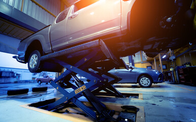 Car on hydraulic lift in auto repair shop