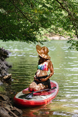 pregnant woman rides a sup under the sun's rays, a healthy lifestyle