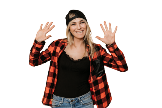 Pretty blonde in baseball cap and checked shirt , broad smiling, shows her palms, posing over transparent background with a copy space for ad. She is ready to celebrate. Happiness concept.