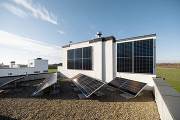 Household power plant installed on a flat roof and vertical wall. Concept of alternative energy and energy independence - obrazy, fototapety, plakaty
