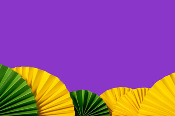 Mardi gras festive traditional color background. Abstract background yellow, green, purple. Paper fans Mardi gras celebration.