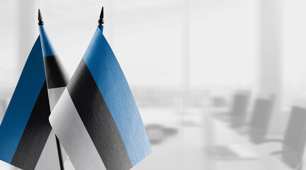 Small flags of the Estonia on an abstract blurry background
