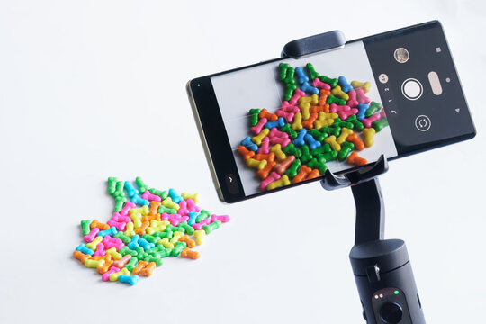 Backstage photography of multi-colored toy male penises on mobile phone. Video streaming and news.  Humorous concept of showing photos of the male penis on social networks, Internet.