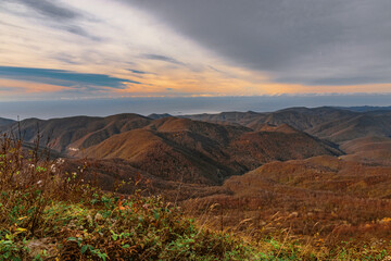 Picturesque view of the peaks of the Caucasus mountains on a sunny day with dramatic clouds. View of the ridge of mountain peaks from a height of 1000 m. A mountain range with high peaks.