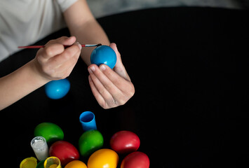 Easter eggs in nest painted by hand in blue color on dark background. Chicken eggs catholic and orthodox easter holiday