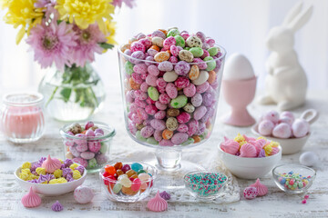 Beautiful festive Easter table with  colorful candy eggs, meringues, sprinkles