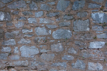 Stone walls are made of huge large bricks with concrete and cement. Sturdy building structure. Textured background with close-up details