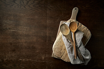 Wooden chopping boards and spoons on a rustic kitchen table. Flat lay. Copy space - 565901624