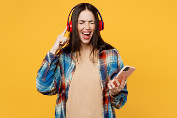 Young excited fun cheerful caucasian woman wears blue shirt beige t-shirt headphones listen music...