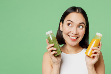Young woman in white clothes hold juice yellow vegetable smoothie detox diet look overhead isolated...
