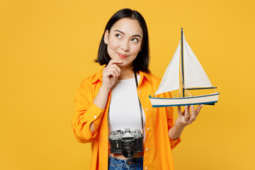 Young minded woman wear summer casual clothes hold ship mockup look aside isolated on plain yellow...