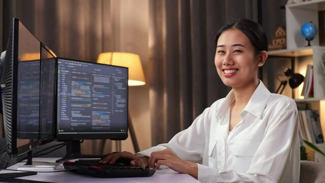 Asian Woman Programmer Smiling And Crossing His Arms While Creating Software Engineer Developing App, Program, Video Game On Desktop Computer At Home

