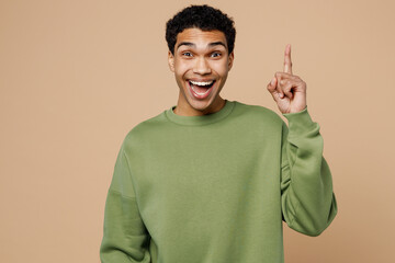 Young fun insighted smart proactive man of African American ethnicity wear green sweatshirt holding...