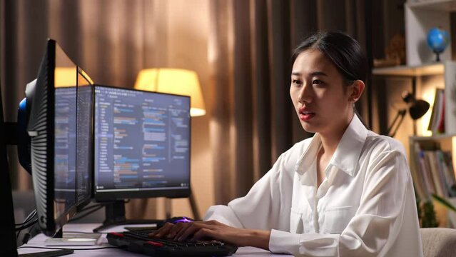 Asian Woman Programmer Yawning While Creating Innovative Software Engineer Developing App, Program, Video Game On Desktop Computer At Home. Terminal With Coding Language 
