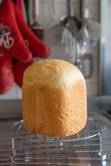 Freshly baked homemade bread from the bread machine cools down on the wire rack the kitchen.